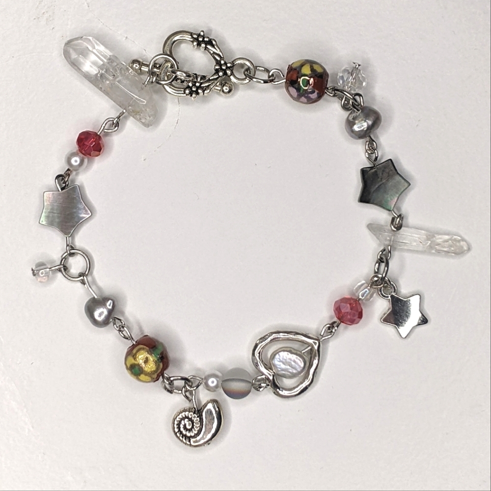 Bracelet with red beads charms crystal beads and a toggle clasp. Handmade by me.